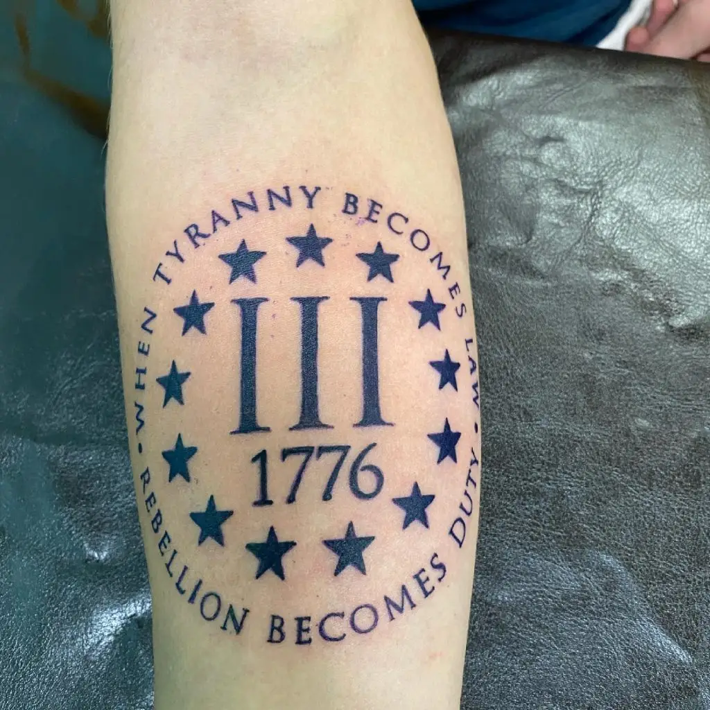 Tattoo of 1776 encircled by stars and the words "When tyranny becomes law, rebellion becomes duty"